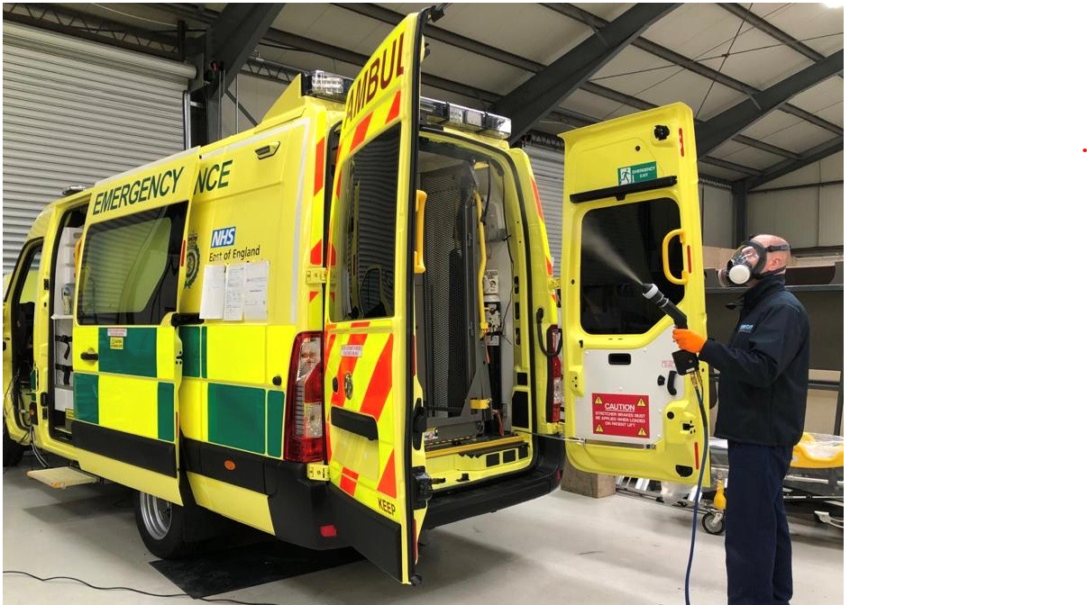 Operator electrostatically spraying the interior of an NHS ambulance